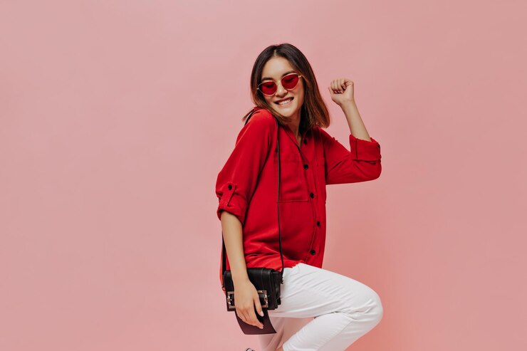 Cool Young Attractive Asian Woman Red Shirt White Pants Sunglasses Smiles Holds Handbag Dances Pink Background 197531 28285